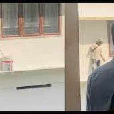 एक कॉलेज की इमारत पेंट कर रहा मज़दूर राष्ट्रगान